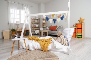 Masada yatak, kanepe ve bebek monitörü olan çocuk odasının içi.