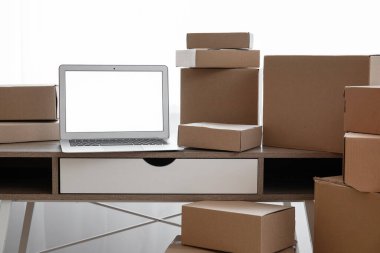 Boş dizüstü bilgisayar, odanın penceresinin yanındaki kutuların taşındığı masada.