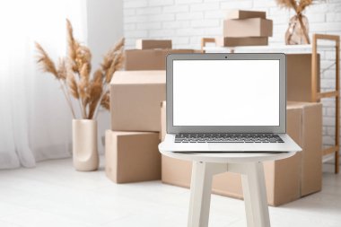 Masada boş dizüstü bilgisayar var. Odada kutular var, yakın plan.