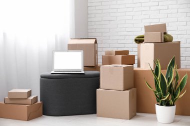 Işık odasında kutuları taşıyan boş bir dizüstü bilgisayar.