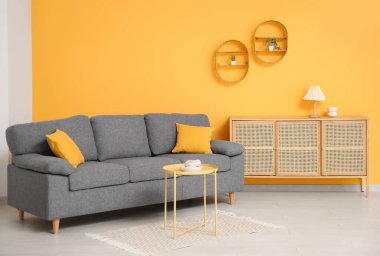 Rahat bir kanepe, sehpa ve oturma odasındaki çekmeceler.