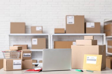 Posta deposundaki masada paketli dizüstü bilgisayar.