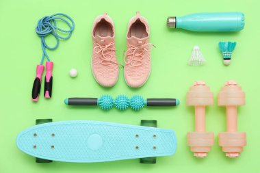 Vücut masajı tekerlekli spor aletleri ve yeşil arka planda kaykay. Üst görünüm