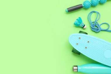 Kaykaylı spor ekipmanları ve yeşil arka planda bir mekik aleti. Üst görünüm