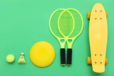 Raketli spor aletleri ve yeşil arka planda kaykay. Üst görünüm