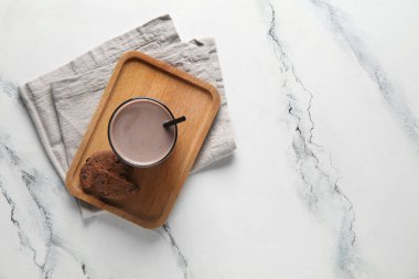 Beyaz arka planda bir bardak çikolatalı süt ve lezzetli kurabiye.