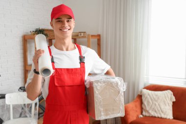 Bir rulo streç film ve bir odaya paketlenmiş erkek işçi.