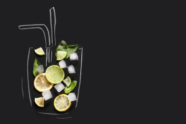 Kamış, dilimlenmiş limon, nane yaprağı ve siyah zemin üzerinde buz küpleri olan çizilmiş cam.