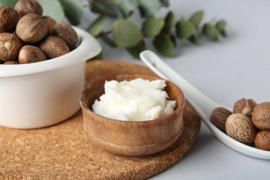 Mantar kesme tahtası, beyaz arka planda tereyağı ve fındık dolu kâseler, yakın plan.