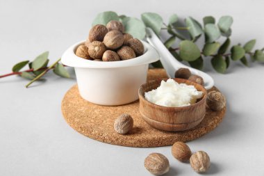 Mantar kesme tahtası, beyaz arka planda tereyağı ve fındık dolu kâseler, yakın plan.