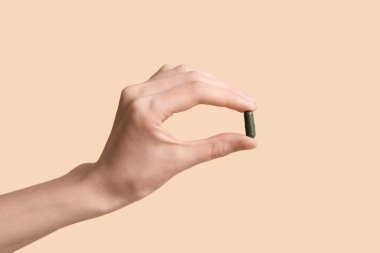 Bej arka planda hapı olan bir kadın el.