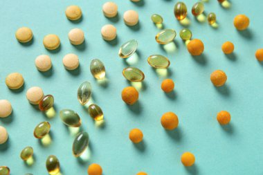 Turkuaz arka planda çok farklı haplar, yakın plan.