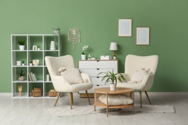 Oturma odasının içinde koltuklar ve kahve masası var.