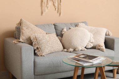 Oturma odasında dergileri olan rahat bir kanepe ve kahve masası.