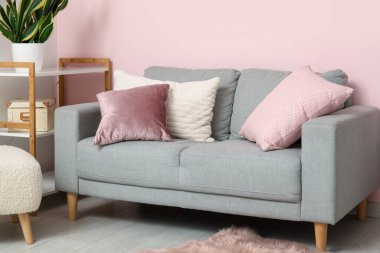 Oturma odasındaki raflarda rahat bir kanepe ve çiçek var.