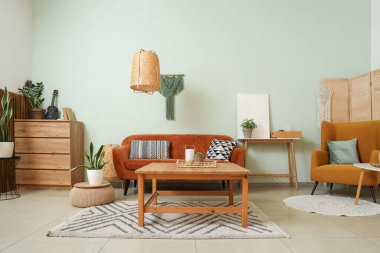 Oturma odasının içinde rahat bir kanepe ve ahşap bir masa.