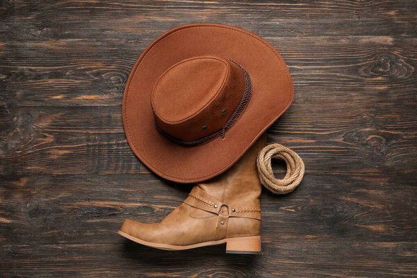 Ковбойская шляпа, сапоги и лассо на коричневом фоне