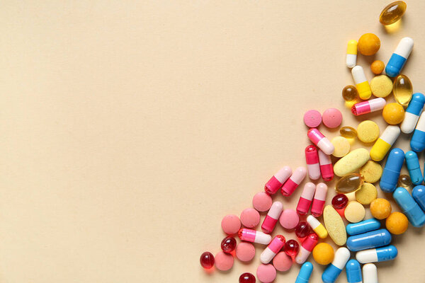 Different pills on beige background, closeup