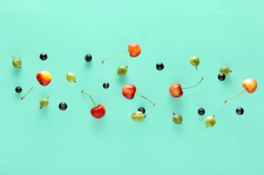 Turkuaz arka planda farklı meyveler uçuşuyor.
