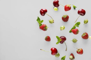 Gri arka planda uçuşan farklı dut ve nane yaprakları, yakın plan