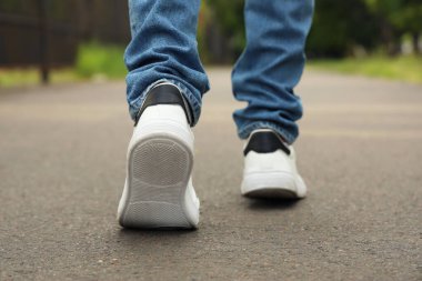 Adam asfalt yolda ilerliyor, yakın plan. Yeni başlangıç kavramı