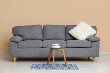 Rahat bir kanepe ve odada bej duvarlı bir sehpa.