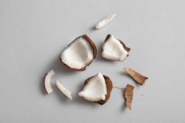 Gri arka planda taze hindistan cevizi parçaları.