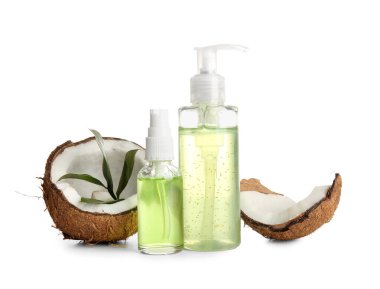 Hindistan cevizi kozmetik yağı şişeleri ve beyaz arka planda yapraklar