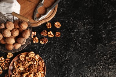 Siyah arka planda lezzetli cevizler olan kase ve sepet.