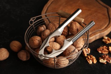 Lezzetli cevizli sepet ve siyah arka planda fındıkkıran.