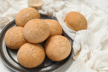 Beyaz ahşap arka planda susam tohumlu taze çörekler.