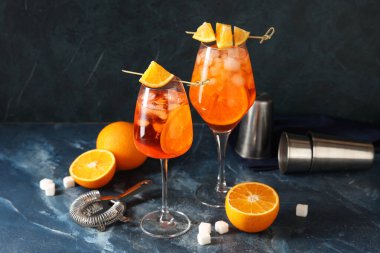 Mavi arka planda meyve ve şekerli Aperol sprey kokteyli.