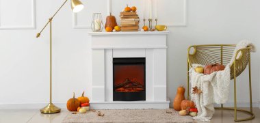 Şömineli, şatafatlı koltuklu ve balkabaklı bir sonbahar salonu.