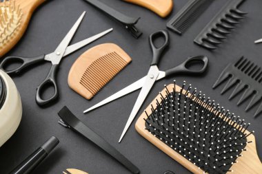 Siyah arka planda kuaför aksesuarları olan kompozisyon, yakın plan.