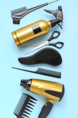 Mavi arka planda kuaför aksesuarları ve kurutma makinesi olan kompozisyon