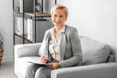 Ofisinde evrakları olan olgun bir iş kadını.