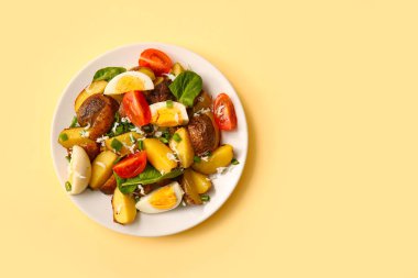 Bej arka planda yumurta ve domatesli lezzetli patates salatası.