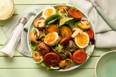 Tahta masada yumurta ve mantarlı patates salatası tabağı.