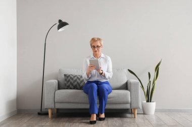 Ofiste tablet bilgisayarla çalışan olgun psikolog.