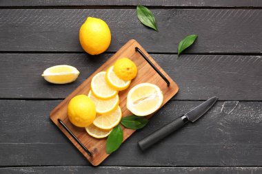Siyah ahşap arka planda taze limonları olan tahta.