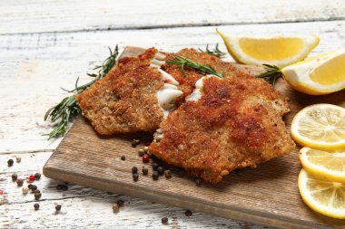 Hafif ahşap arka planda kızarmış morina balığı, yakın plan.