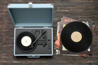 Koyu ahşap arka planda vinil diskleri olan kayıt çalar