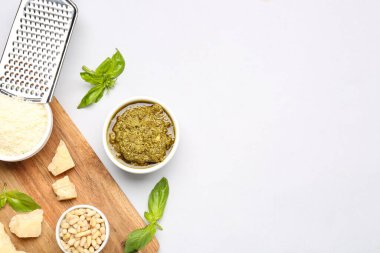 İçinde pesto sosu ve gri arka planda malzemeler olan kompozisyon.