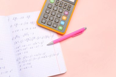 Matematik formülleri, pembe arkaplan üzerinde kalem ve hesap makinesi olan metin kitabı