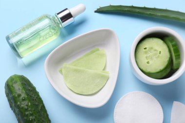 Mavi arka planda pamuklu göz altı bantları, salatalık, aloe ve damlalık şişeleri