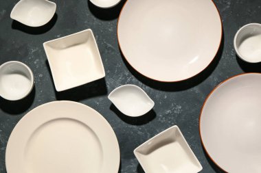 Siyah grunge masasında temiz tabaklar ve kâselerle kompozisyon