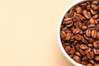 Soluk sarı arka planda aromalı kahve çekirdekleri.