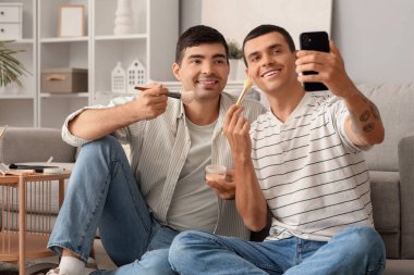 Makyaj fırçalı gençler evde selfie çekiyorlar.