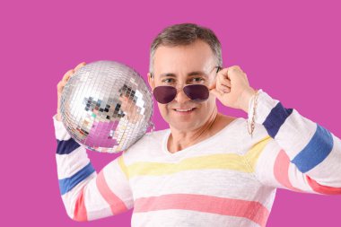 Mor arka planda disko topu olan havalı olgun bir adam.