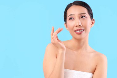 Mavi arka planda güzel bir Asyalı kadın, yakın plan.